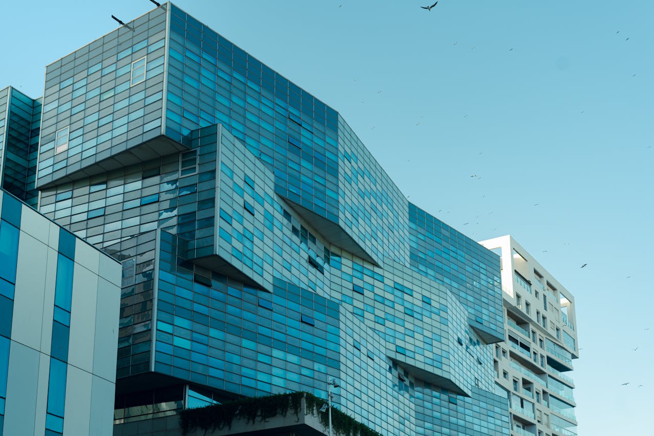 A strikingly modern glass-façade building in Casablanca's urban environment on a clear day.